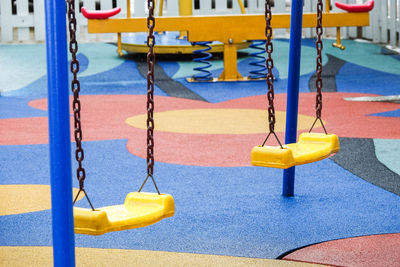 Yellow swings hanging in playground