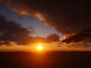 Scenic view of silhouette field against sky during sunset