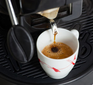 Espresso machine making coffee with paper pod.