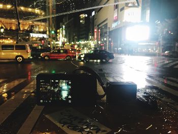 Cars on illuminated street at night