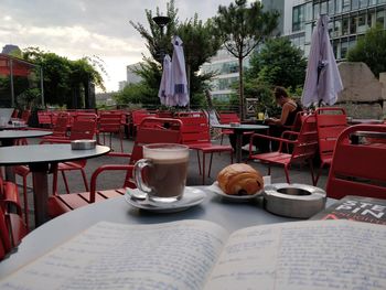 Chairs and tables at sidewalk cafe by building