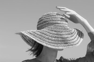 Rear view of woman wearing hat against clear sky