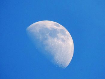 Low angle view of moon against blue sky