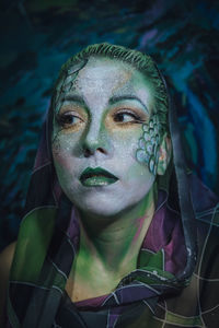 Woman with painted face against painting