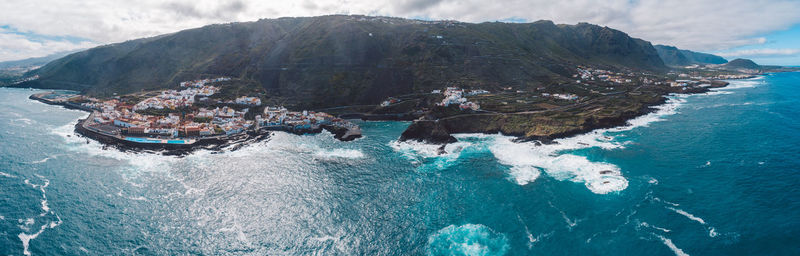 High angle view of sea by mountains