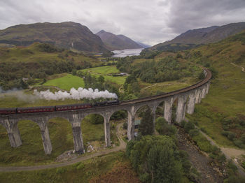 Arch bridge over mountains against sky