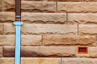 Blue pipe on stone wall