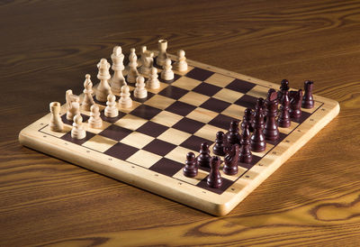 High angle view of chess pieces on wooden table