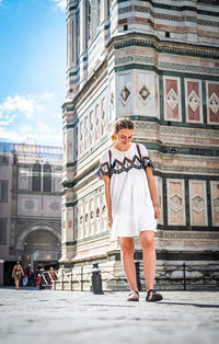 Full length portrait of woman standing on street