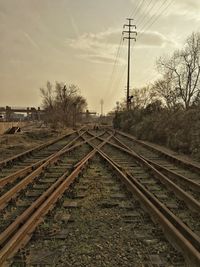 Railway tracks by trees against sky
