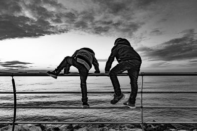 Men on beach against sky