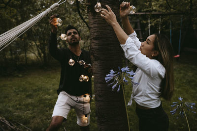 Rear view of mother and daughter on flowering plants