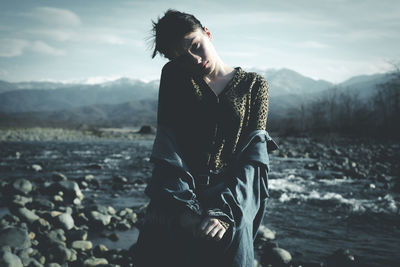 Portrait of woman standing at riverbank