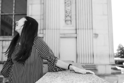 Midsection of woman sitting in city