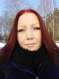 Close-up portrait of smiling woman in snow