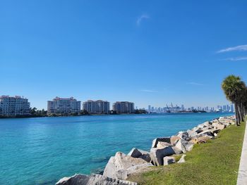 Buildings by sea against sky