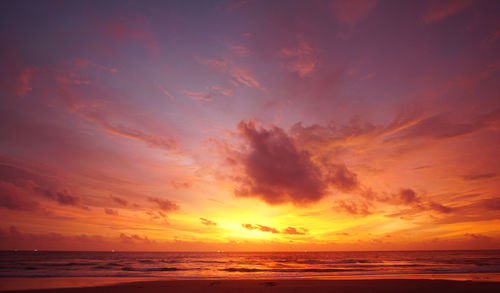 Scenic view of sea against dramatic sky during sunset