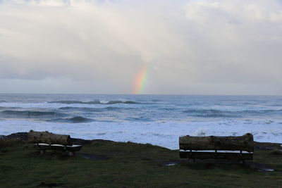 Scenic view of rainbow over sea against sky