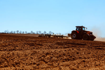 Tractor working on the agricultural field . tractor cultivating field at spring season 