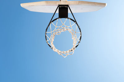 Low angle view of basketball hoop against clear blue sky