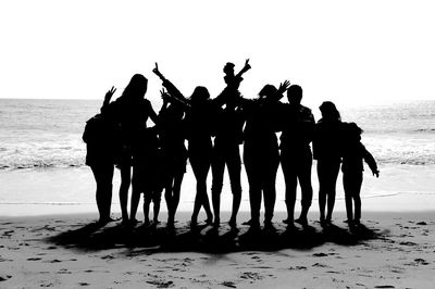 Silhouette people on beach against sky