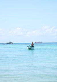 People in boat on sea against sky