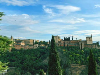 Buildings in city against cloudy sky