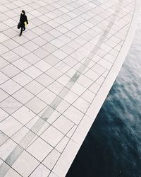 Low section of woman walking by swimming pool