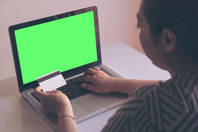 Woman doing online shopping through laptop at home