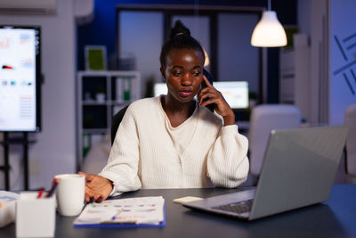 Woman talking on phone while sitting at office