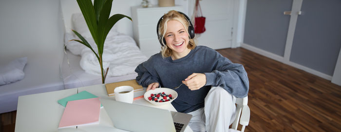 Portrait of young woman sitting on floor at home