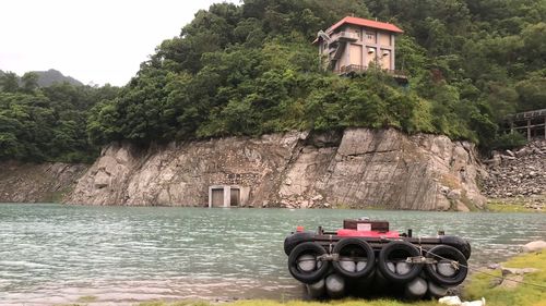 Abandoned building by river against mountains