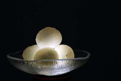 Close-up of fruits in bowl against black background