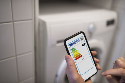 Person checking energy labels on phone
