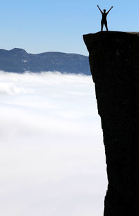 Silhouette man standing on mountain against sky