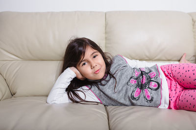 Portrait of girl lying on bed at home