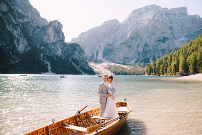 People on lake against mountains