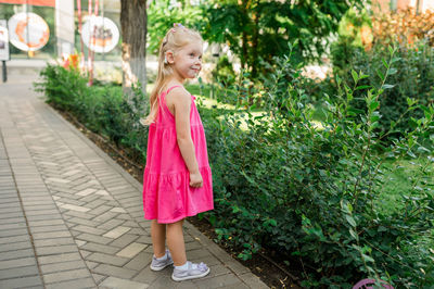 Portrait of young woman walking on footpath