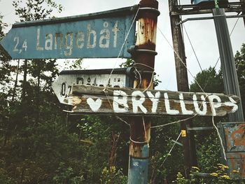 Low angle view of road sign against trees