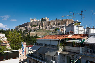 Buildings in city against blue sky