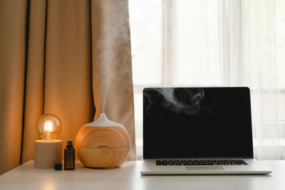 Aroma oil diffuser in work place, laptop and home decor