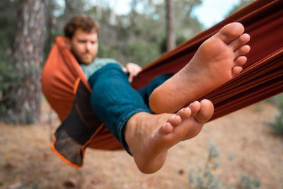 Full length of man sitting on hammock in forest