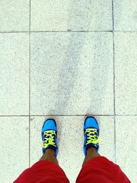 Low section of man standing on tiled floor