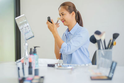 View of woman doing make-up