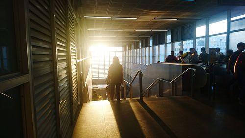 People in illuminated corridor