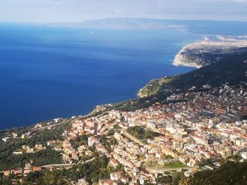 High angle view of townscape by sea against sky