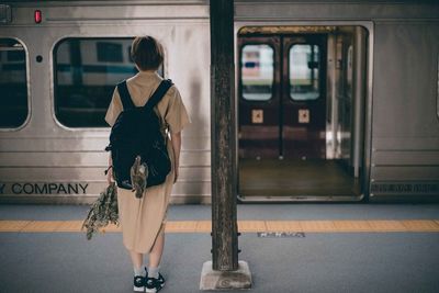 Rear view of woman on train at railroad station platform