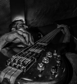 Low angle view of musician playing guitar during concert at night