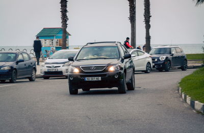 Cars on street in city against clear sky