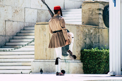 Rear view of man holding umbrella